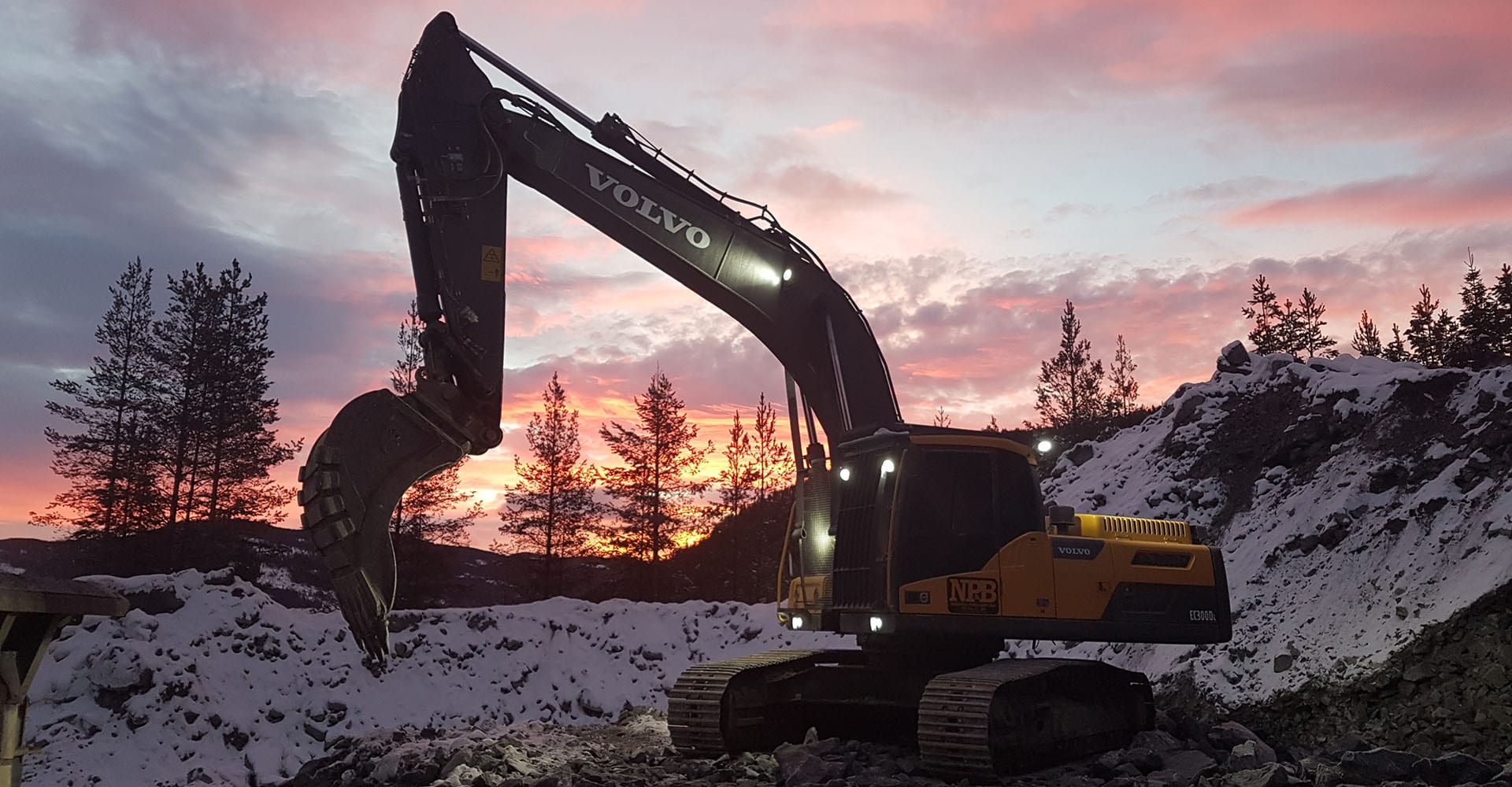 Gravemaskin i solnedgang